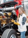 image of woman checking truck engine
