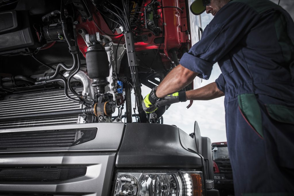 Driving Instructor Repairing Broken Semi Truck Tractor Engine.